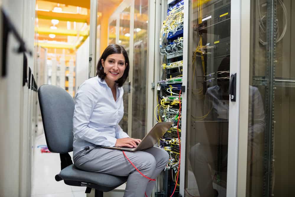 Portrait of technician working on laptop in server room Portrait of technician working on laptop in server room
